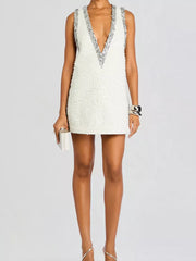 White sequin mini dress with deep V-neck and silver sequin trim.