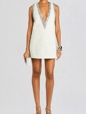 White sequin mini dress with deep V-neck and silver sequin trim.