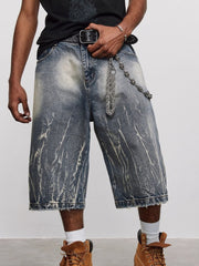 Men's loose fit blue washed denim shorts with distressed details and a chain accessory.