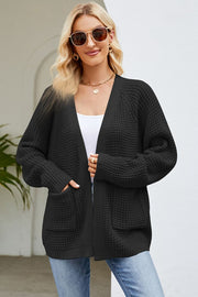 Black waffle knit cardigan with patch pockets and open front.