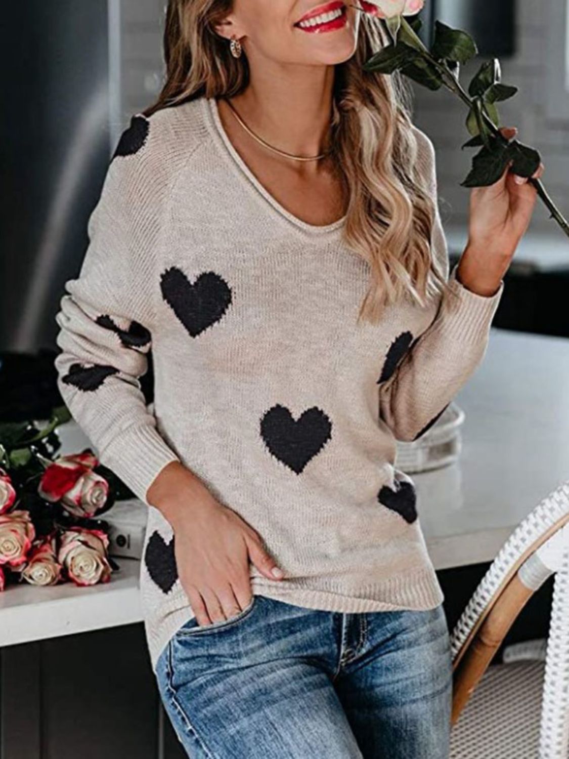 Eggshell knit sweater with black heart motif, V-neck, long sleeves, casual style.