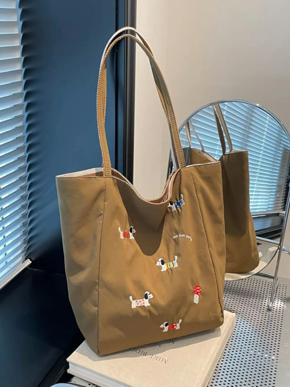 Brown shoulder bag with embroidered dachshunds and "fun fun party" text