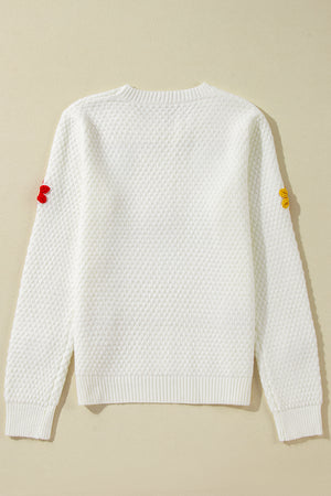 White knit sweater with crochet floral embellishments on sleeves, crew neck, long sleeves.