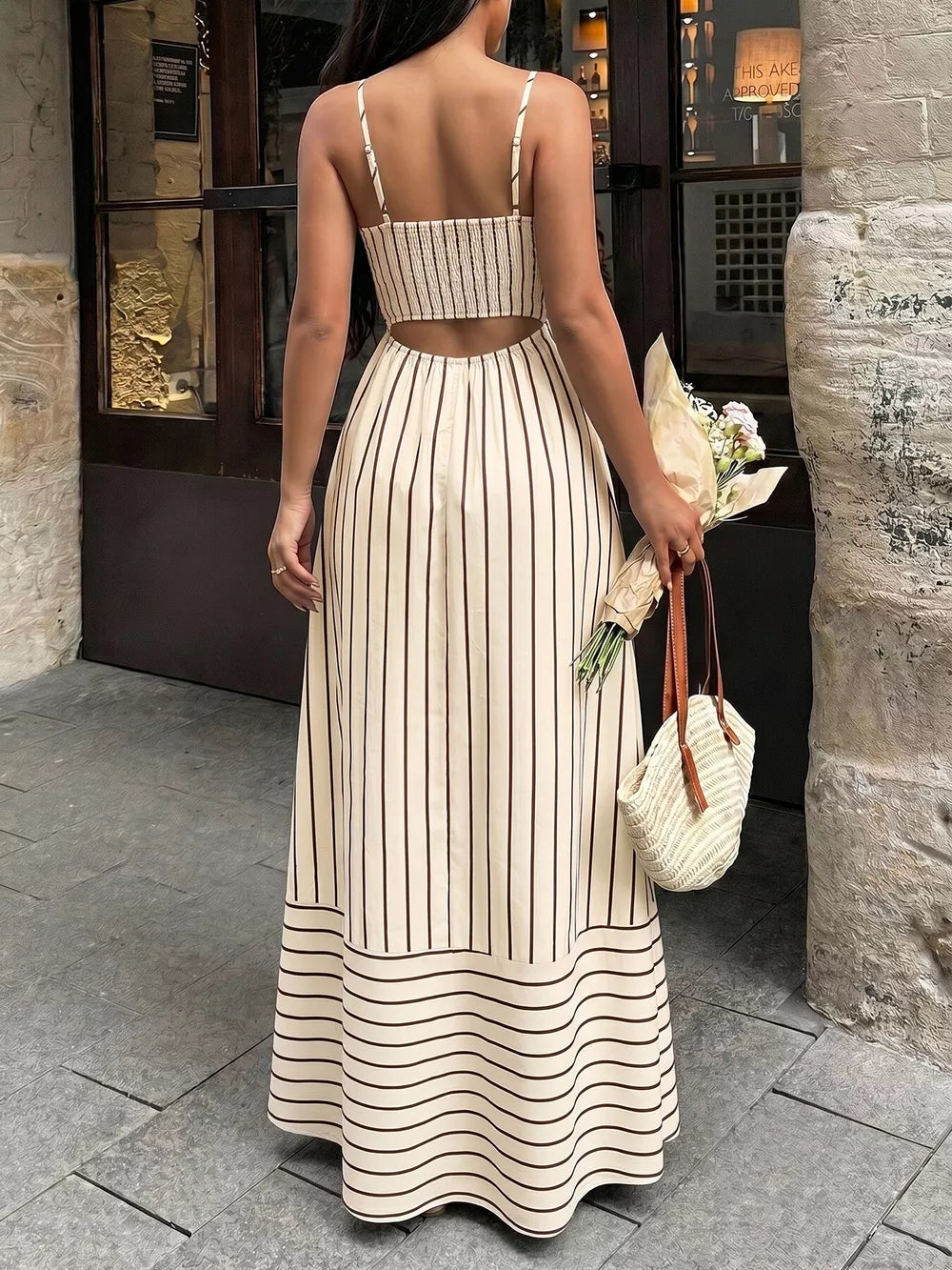 Patterned cutout maxi dress with smocked detail, featuring vertical stripes and a tiered hem.
