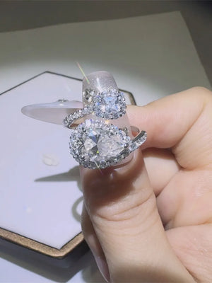 Silver halo engagement rings with large pear and square cut diamonds.