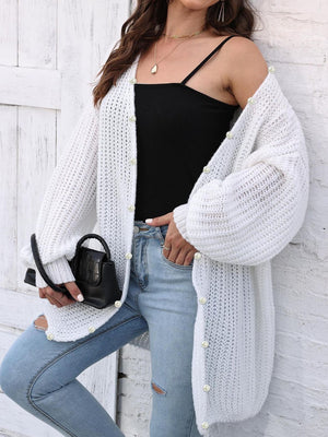 White balloon sleeve cardigan with pearl buttons and open knit detail.
