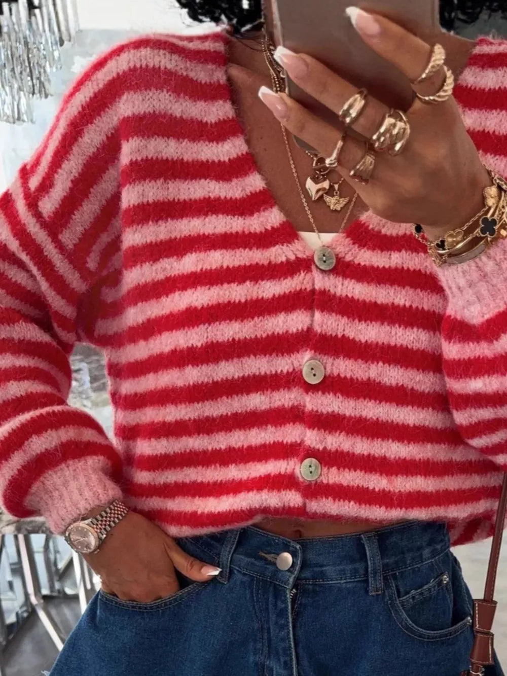 Charming cropped knit cardigan with red and pink stripes, button front, and balloon sleeves.