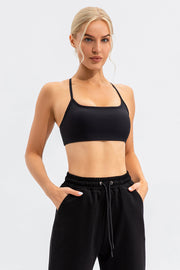 Black sports bra with thin straps and square neckline, paired with black sweatpants.