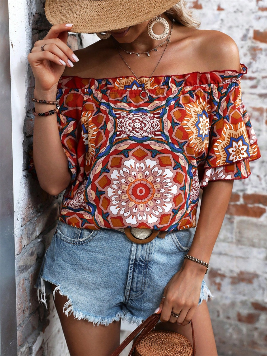 Bohemian ruffled off-shoulder blouse in terracotta with a bold mandala print and tiered sleeves.
