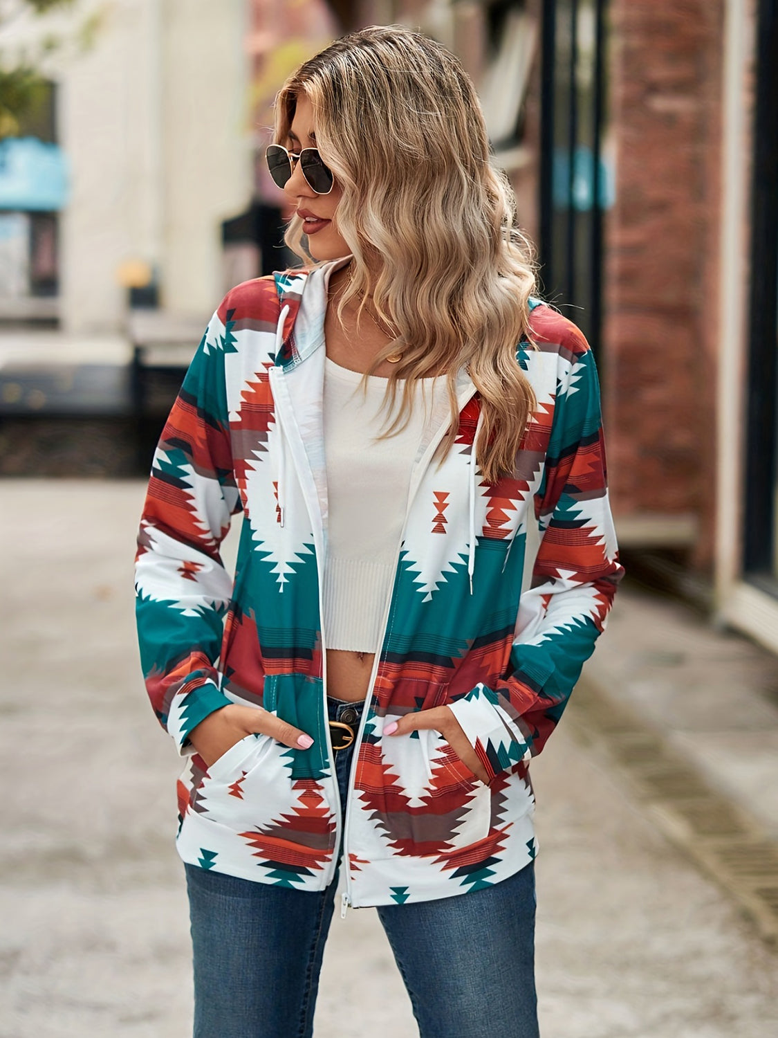 Aztec print zip-up hooded jacket with white, teal, rust, and brown geometric pattern.