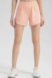 Layered performance running shorts in watermelon pink with elastic waistband and curved hem.