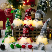 Illuminated knit gnomes in red, dark gray, and dark green with snowflake patterns and glowing bases.