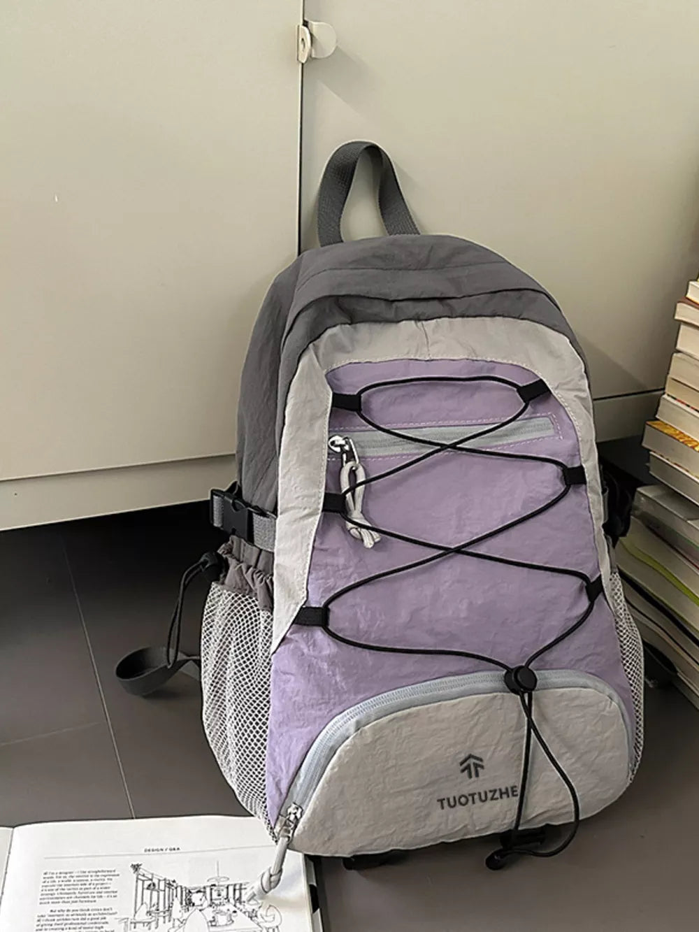 Lightweight nylon hiking backpack in purple and beige with bungee detailing and mesh side pockets.