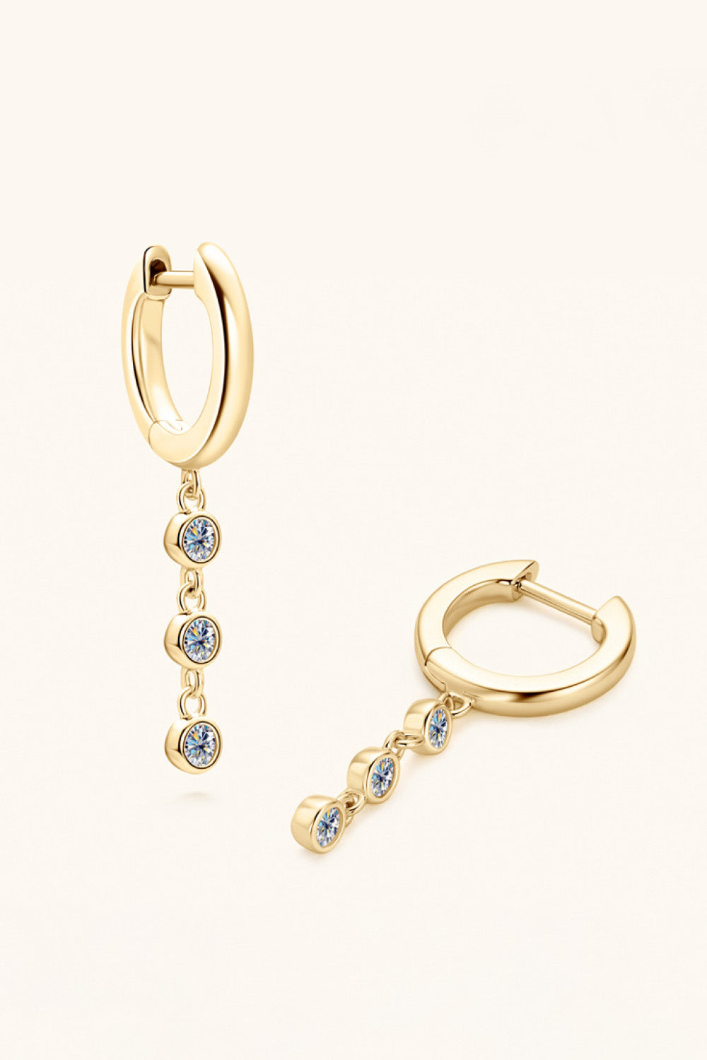 Gold dangling gemstone sterling hoop earrings with three clear stones each.