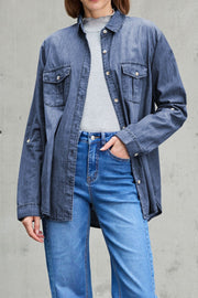 Relaxed light blue denim shirt with patch pockets and button front, styled casually.