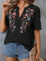 Black v-neck tee with colorful floral embroidery and crochet trim detail.