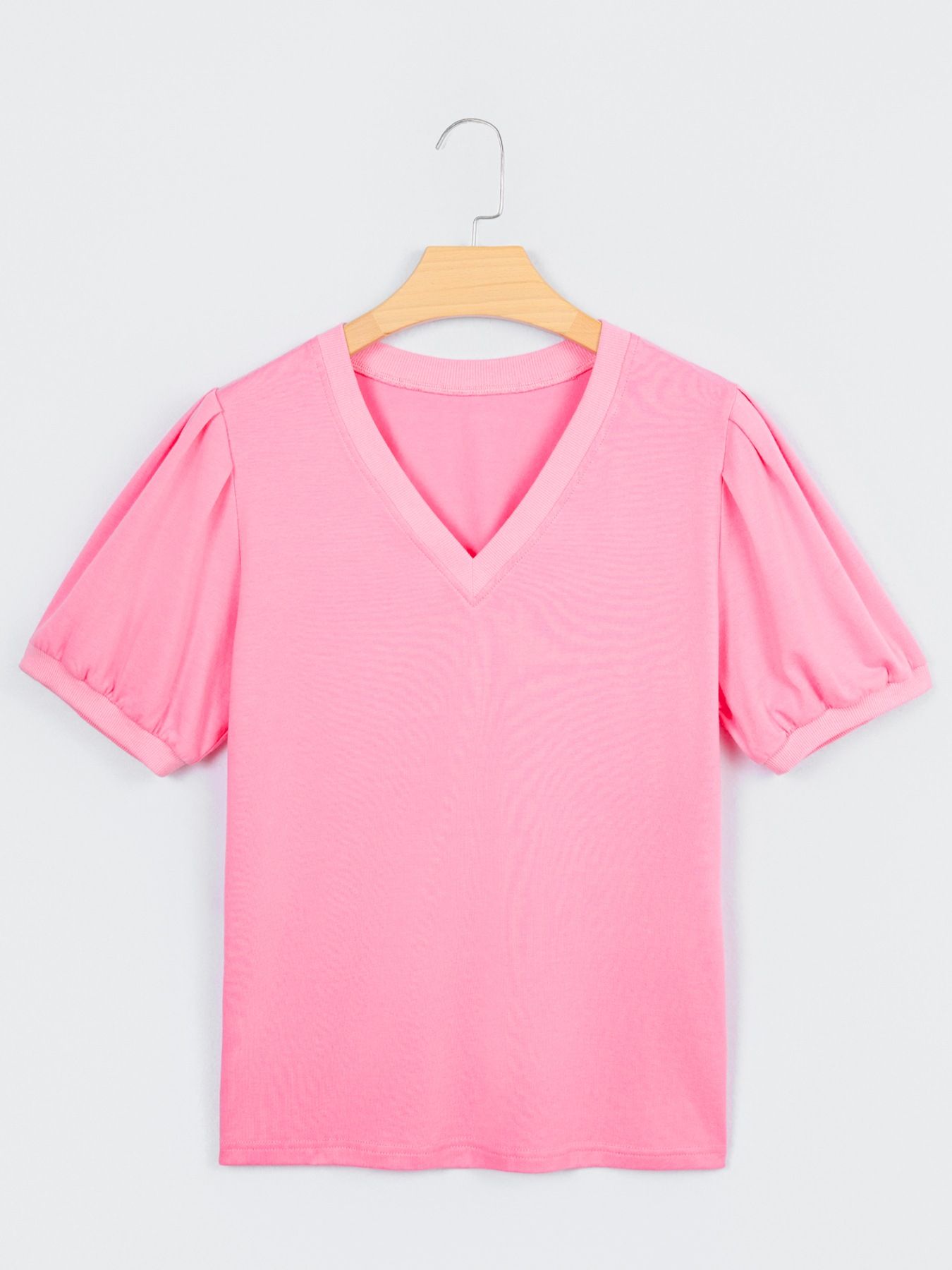 Pink cotton v-neck blouse with short puff sleeves and a relaxed fit.