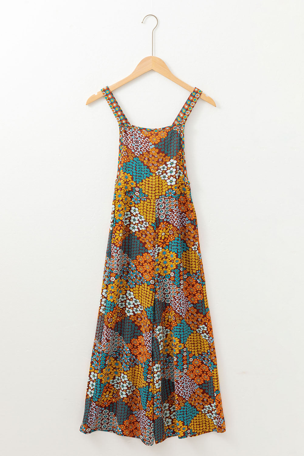 Floral patchwork culotte jumpsuit with wide legs and adjustable straps.