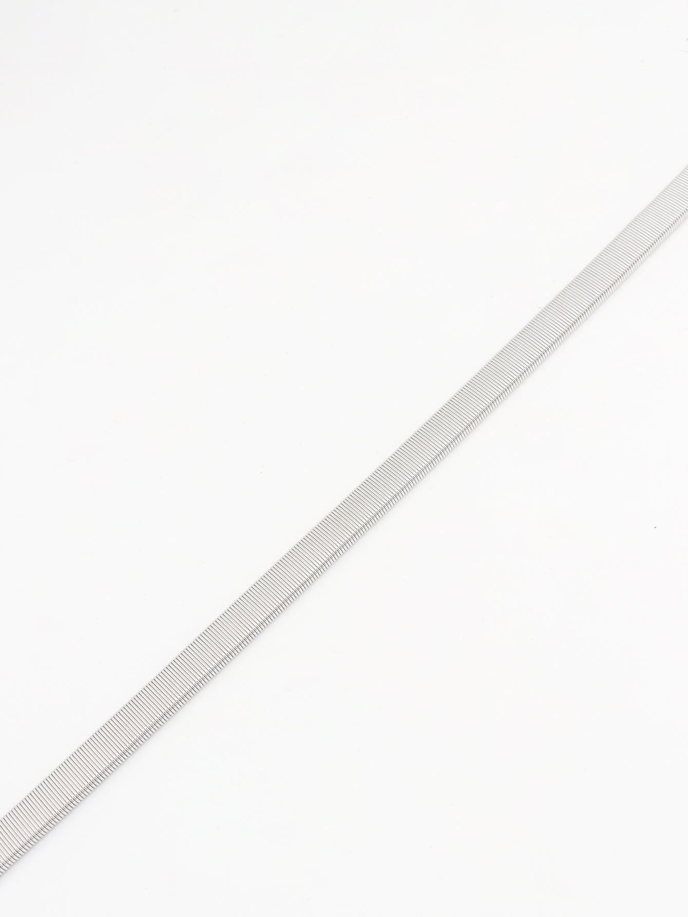 Silver metal mesh belt with a ribbed texture, styled as a waist accessory.