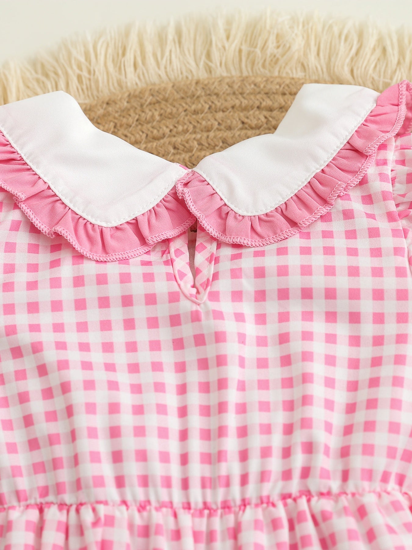 Pink gingham baby one-piece with white Peter Pan collar and ruffled trim