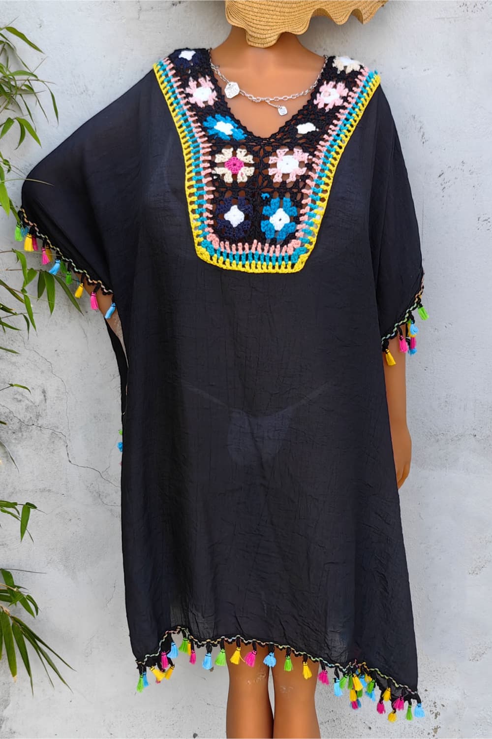Black kaftan dress with colorful crochet yoke and tassel trim on sleeves and hem.