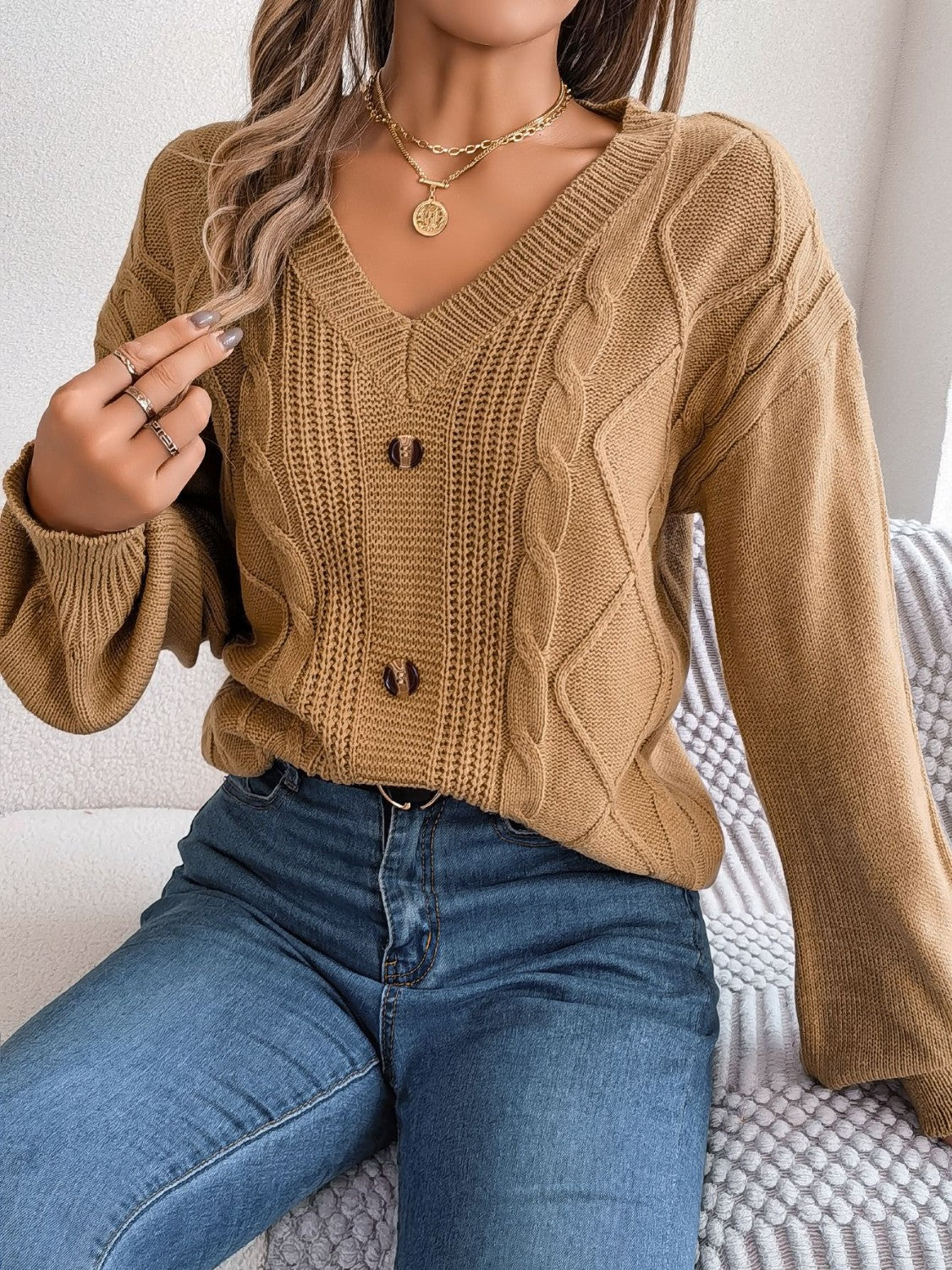 Khaki cable knit button-front cardigan with V-neck and long sleeves.