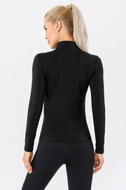 Black athleisure zip-neck top with long sleeves and seam details.