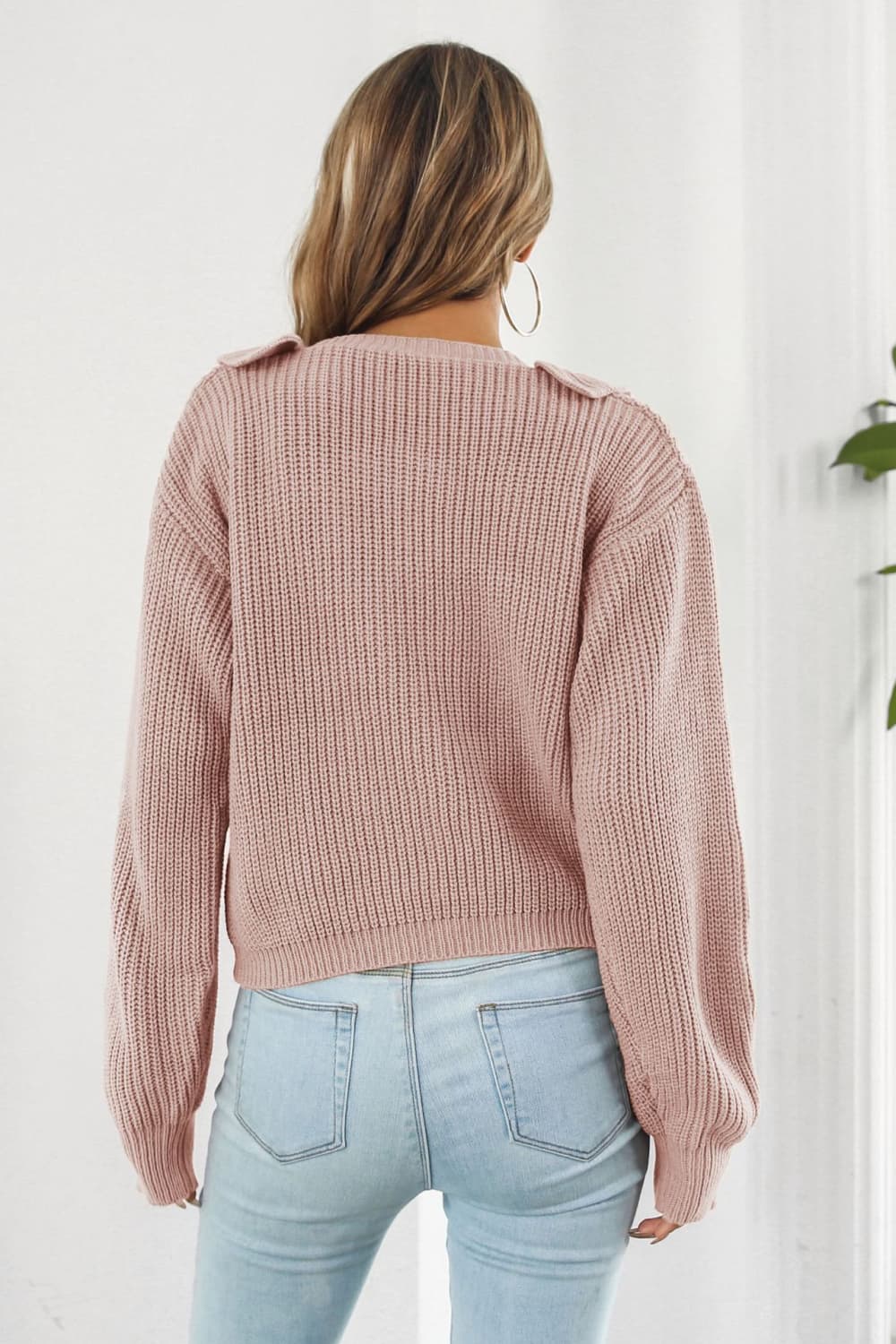 Dusty pink acrylic knit cardigan with ruffled collar detail, long sleeves, and ribbed texture.