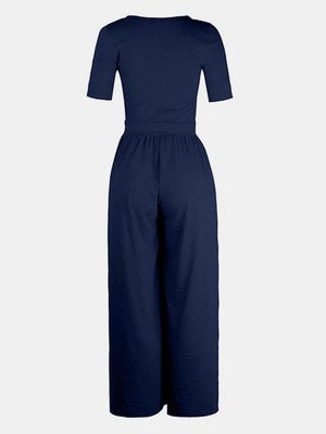 Dark blue textured wide-leg maternity jumpsuit with short sleeves and elastic waist