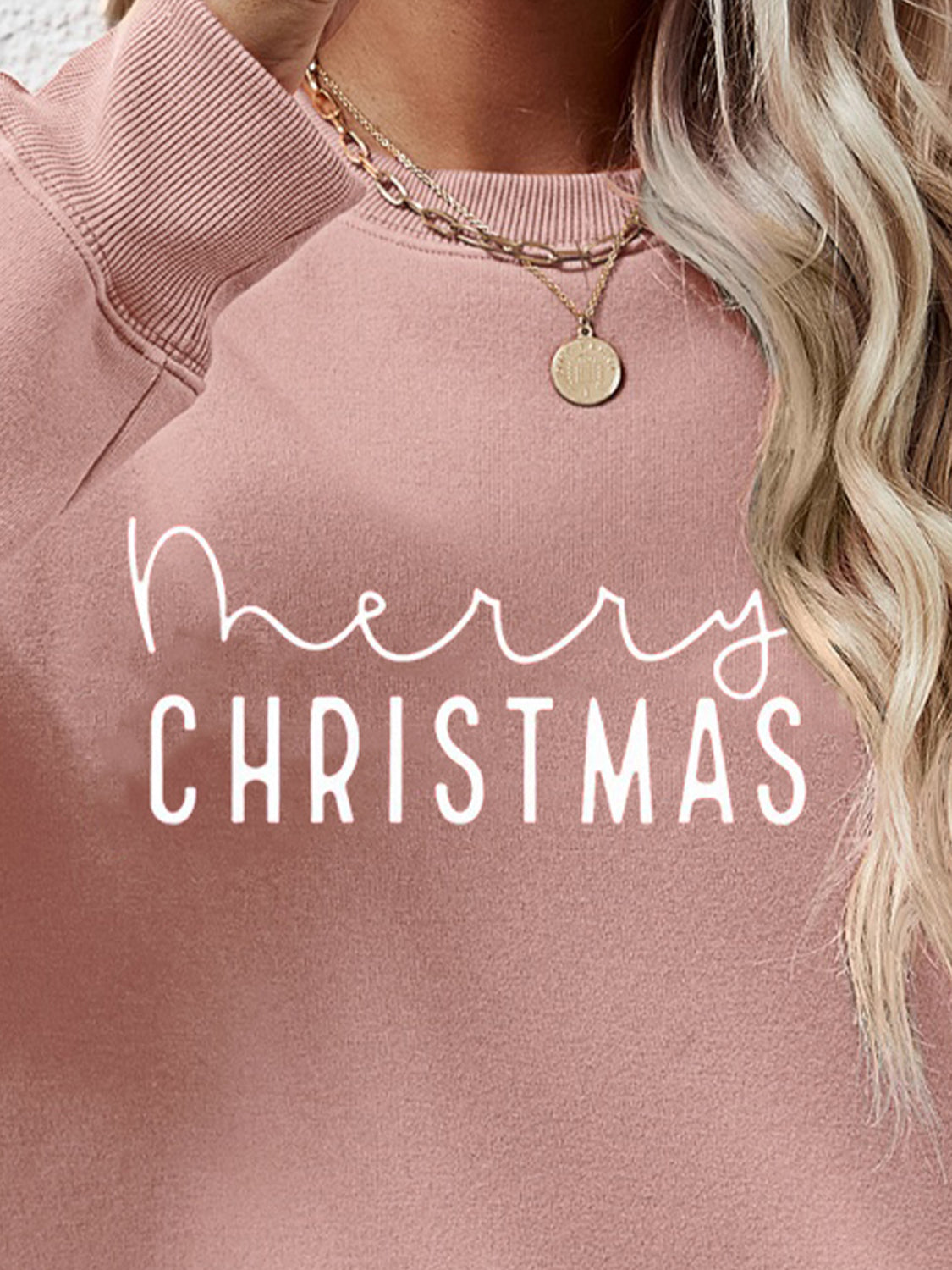 Blush pink crewneck sweatshirt with white Merry Christmas graphic, casual style.