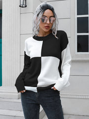 Colorblock knit sweater with black and white checkerboard pattern, crew neck, and long sleeves.