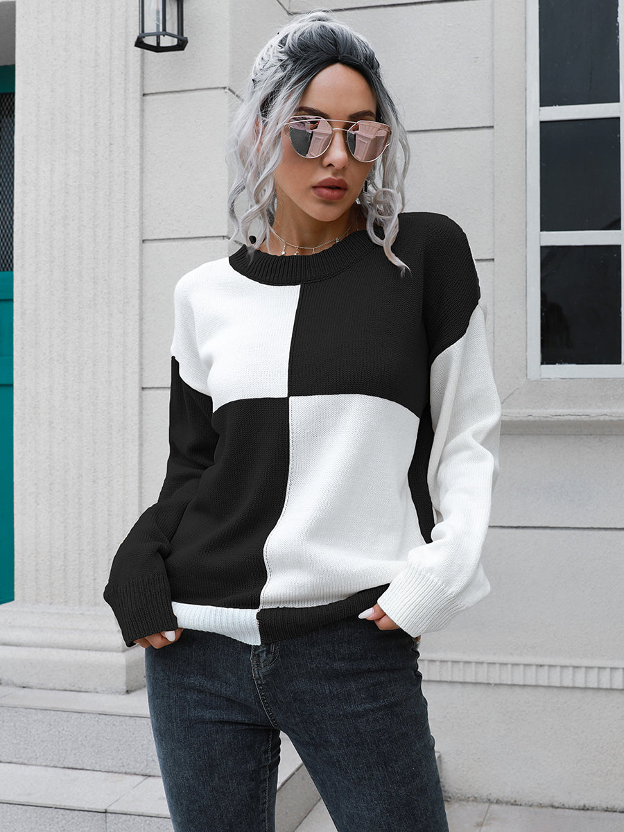 Colorblock knit sweater with black and white checkerboard pattern, crew neck, and long sleeves.
