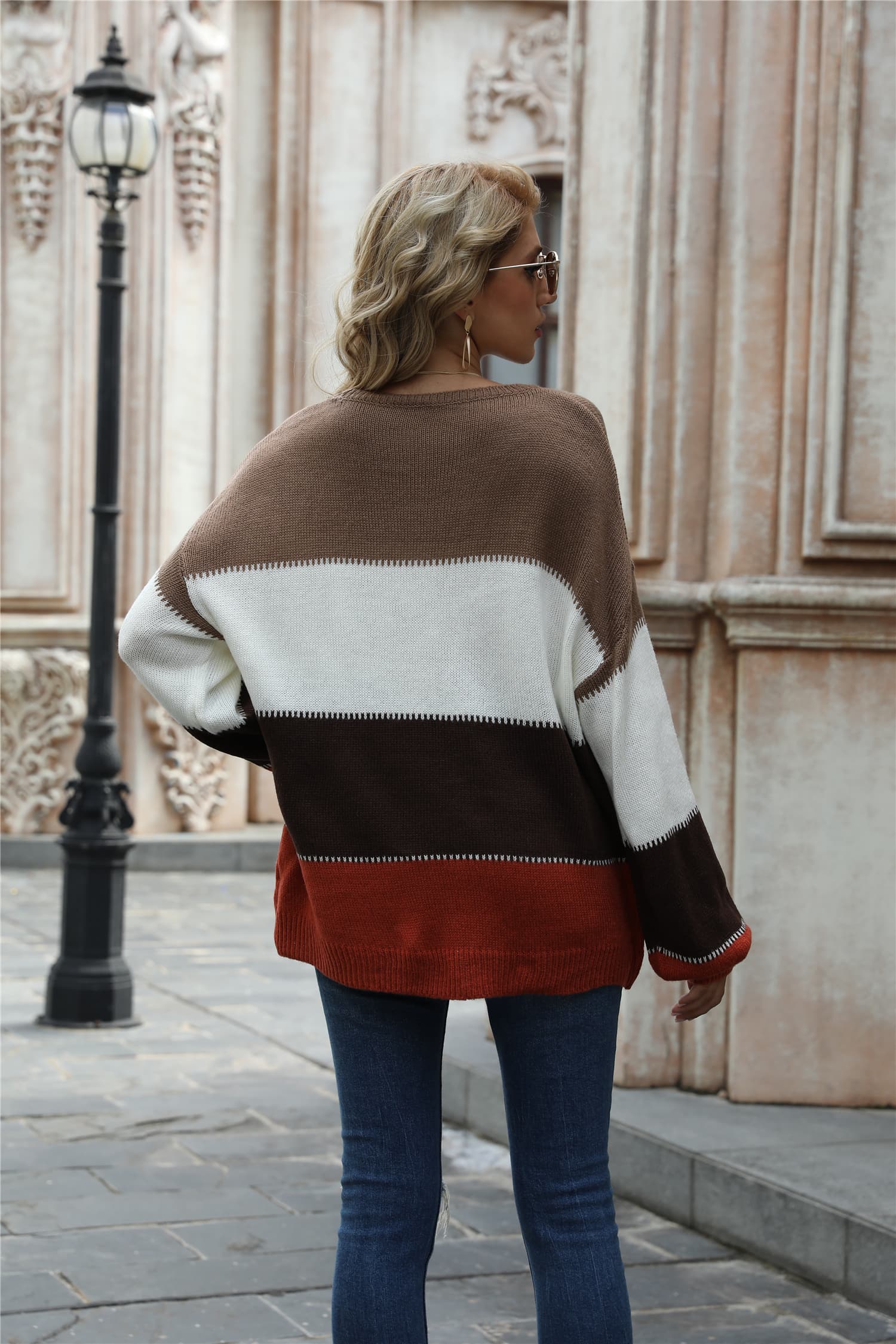 Acrylic crewneck sweater with horizontal color blocks in brown, white, dark brown, and rust.