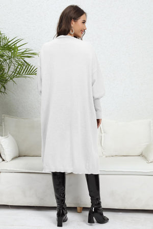 Oversized white knit cardigan with pockets and long sleeves, shown from the back.