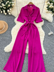 Belted wide-leg jumpsuit in pink with short sleeves and buttoned pockets.
