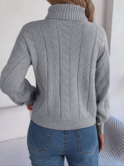 Light gray cable knit turtleneck sweater with drop shoulder and chevron pattern.