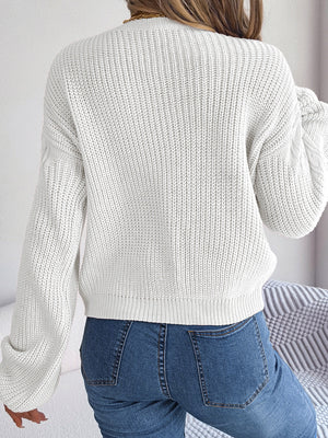 White cable knit drop shoulder pullover sweater with balloon sleeves.