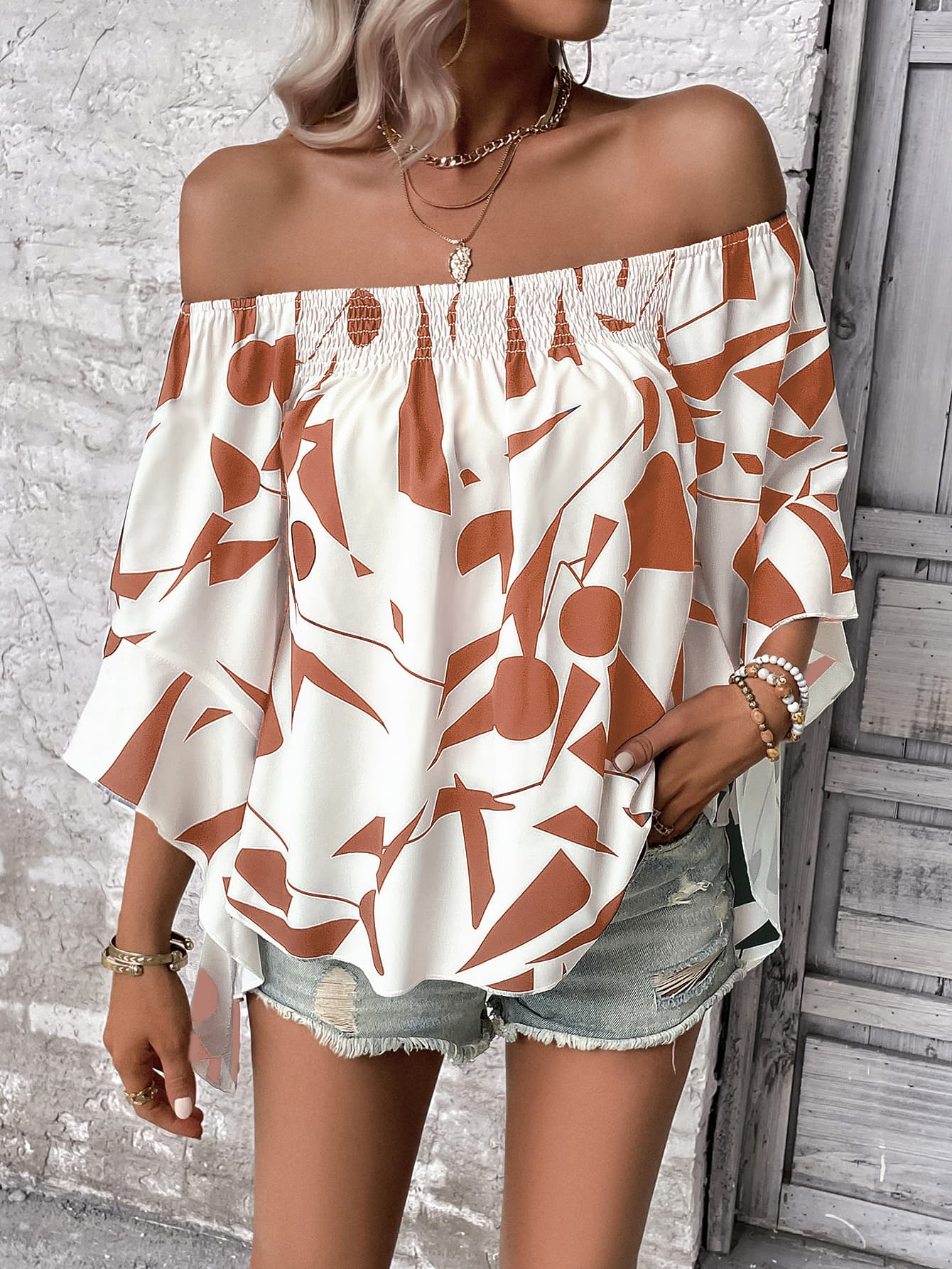 Off-shoulder white blouse with geometric print and flared sleeves
