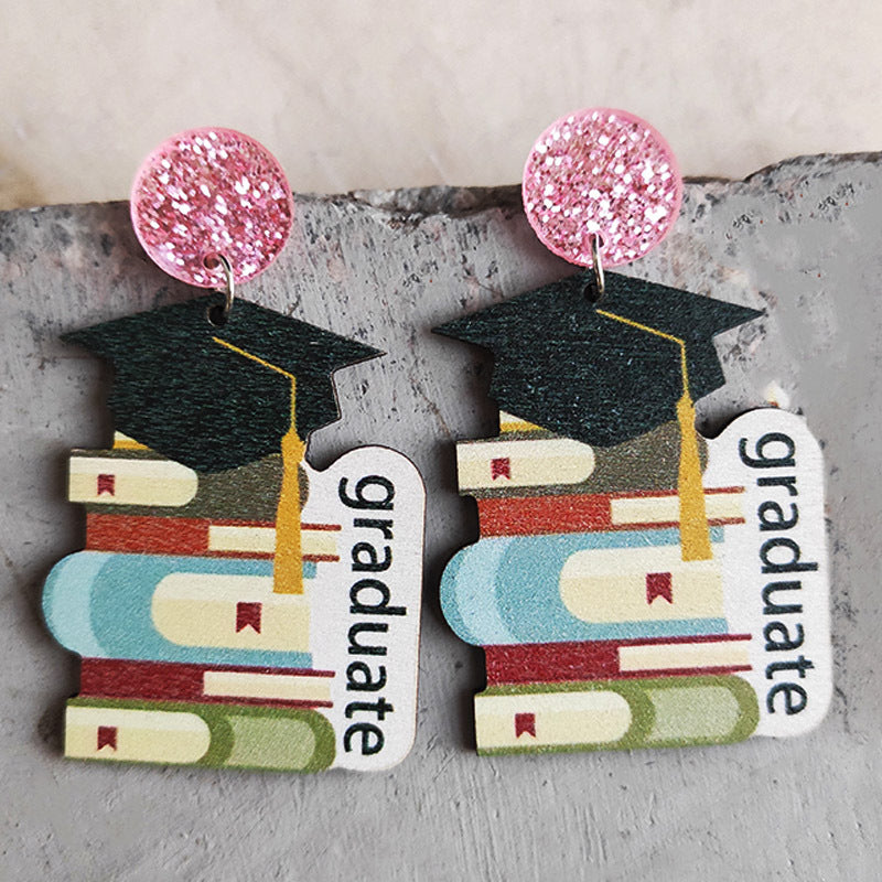 Graduation stacked book drop earrings with pink glitter tops and "graduate" text.