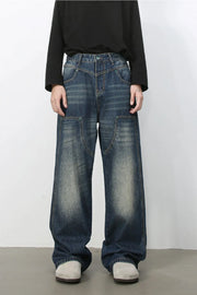 Artisan distressed wide-leg jeans in medium wash denim with unique pocket details.