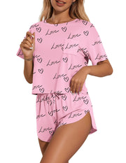 Pink pajama set with heart and love print, crew neck tee with pocket, and drawstring shorts.