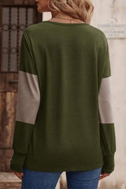 Green knit top with taupe colorblock sleeves and button cuffs.