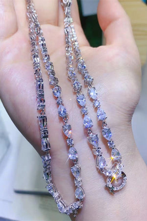Silver necklace with pear and baguette cut moissanite stones, featuring a halo drop pendant.