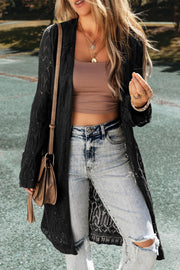 Black openwork maxi cardigan with a relaxed fit, styled with a crop top and distressed jeans.