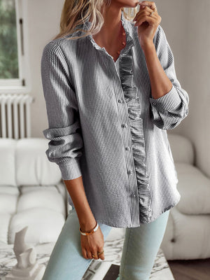 Textured striped blouse with ruffle trim and button front, styled with light wash jeans.