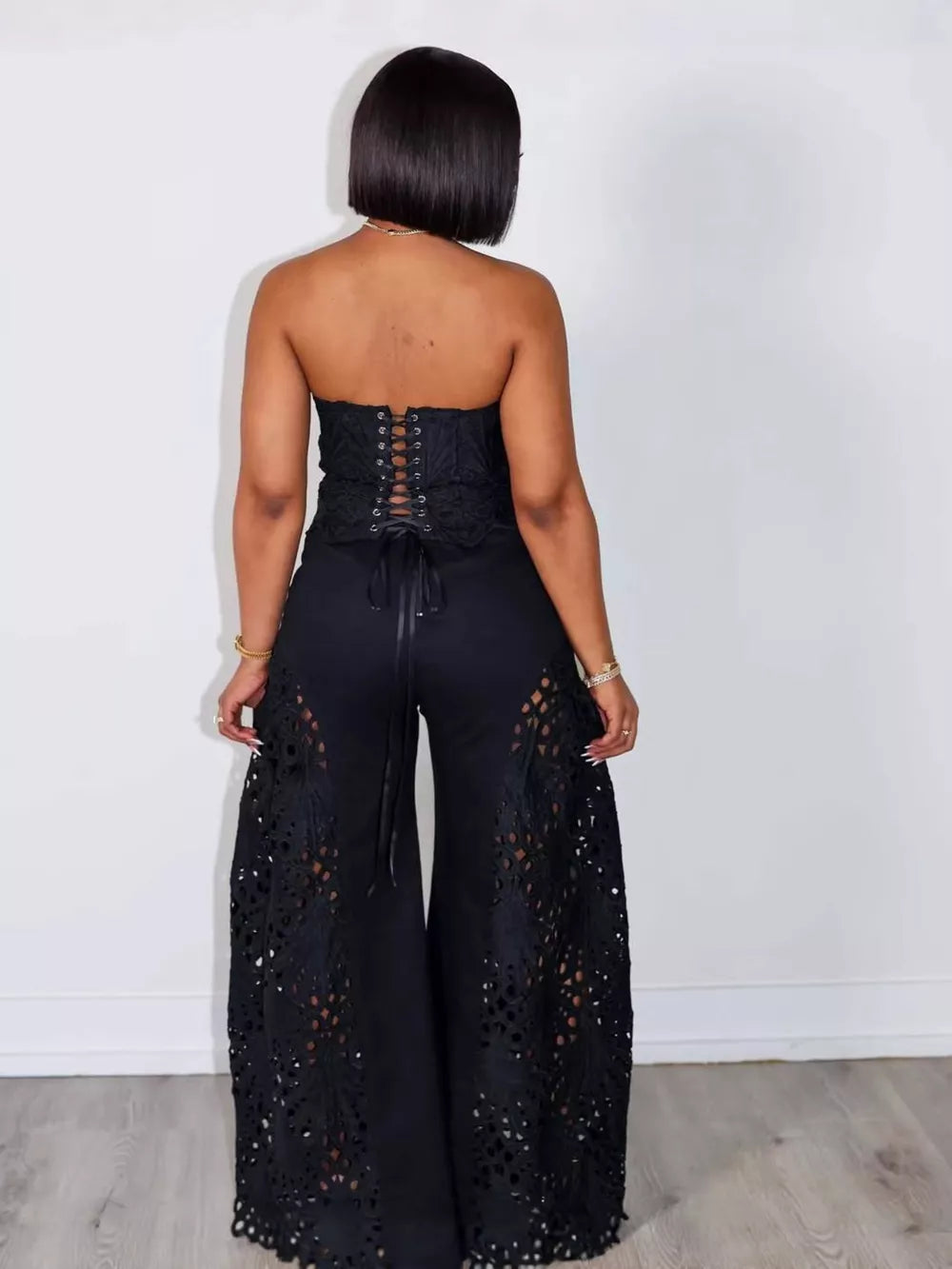 Black lace cutout tube top and wide-leg pants set with corset back detail.
