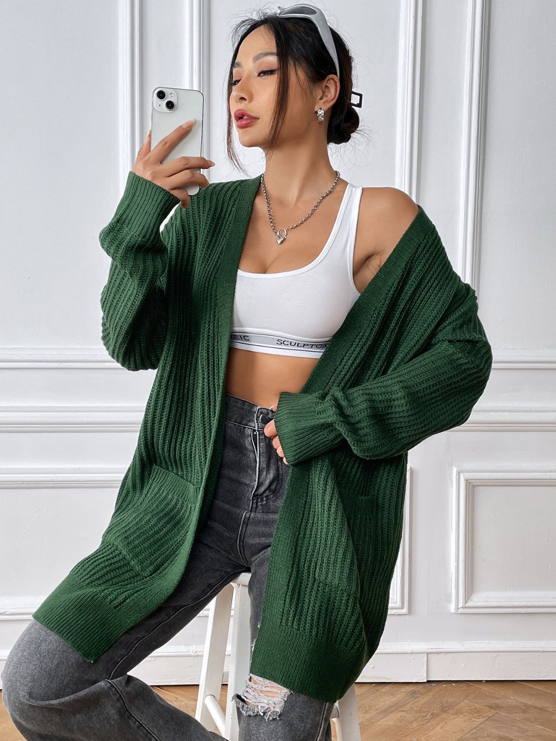 Ribbed knit pocket cardigan in Black Forest acrylic with an open front and long sleeves.