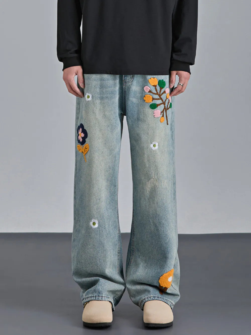 Appliquéd relaxed fit blue cotton jeans with embroidered floral details.