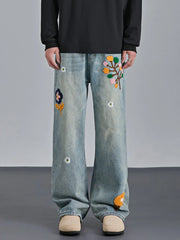 Appliquéd relaxed fit blue cotton jeans with embroidered floral details.