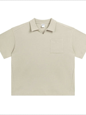 Beige boxy knit polo shirt with short sleeves, V-neck, and a patch pocket.